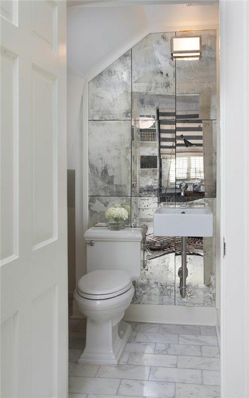 plaukiojantis praustuvas ir matomas čiaupas, veidrodinės plytelės, baltos durys, suoliukas su tualetu