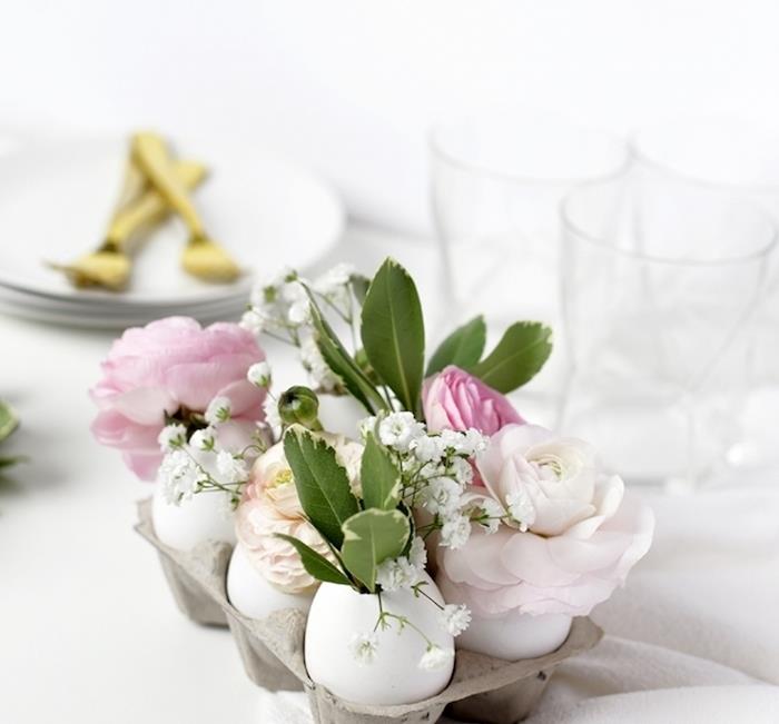 Bir yumurta kutusunda küçük kır çiçekleri buketleriyle bir vazoya dönüştürülmüş yumurta kabuğu merkez parçası