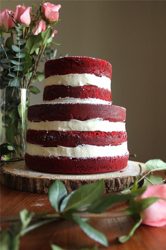 raudonas aksominis pyragas ant medinio rąsto, vanilinis kremas, kaimiškos rožės, gimtadienio tortas
