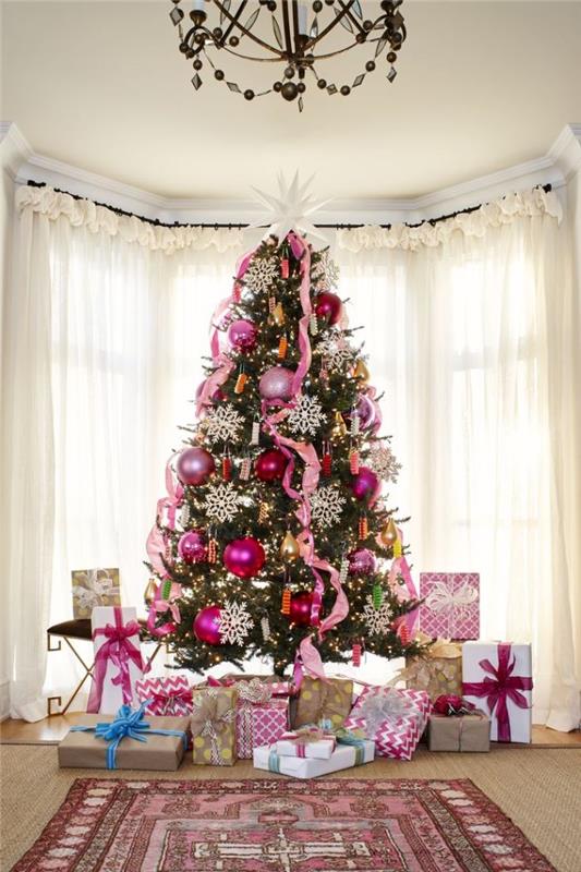 fotografija čudovitega božičnega drevesa, okrašenega z modrimi in rožnatimi zlatimi kroglicami ter belimi snežinkami deco girland trakovi rožnato drevesno stopalo v darilnih paketih