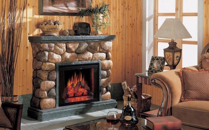 Faux akmens padirbtas židinys su elektriniu netikru ugnies ekranu gyvenamajame kambaryje su vasarnamio stiliaus apdaila su medinėmis sienomis ir antikvariniais baldais