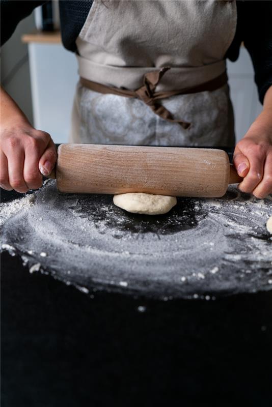 Açılan hamur, naan ekmeği tarifi, siyah yüzeye yerleştirilmiş, unla kaplanmış