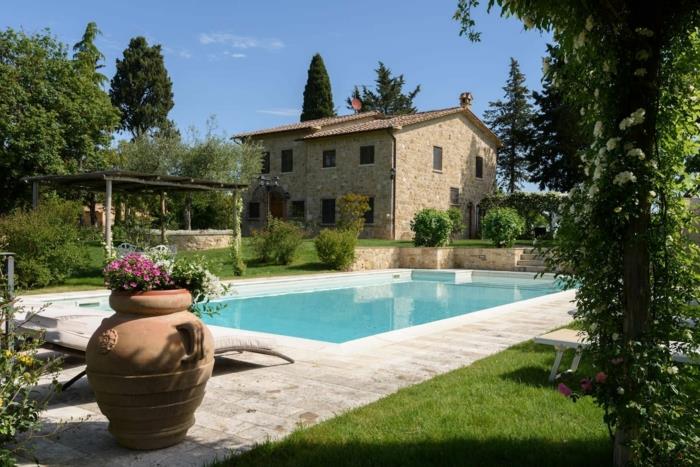 Bahçenizi bir yüzme havuzu, çiçeklerle dolu büyük bir Yunan vazosu, yeşil bir çim, oldukça taşralı bir taş ev ile nasıl dekore edebilirsiniz?