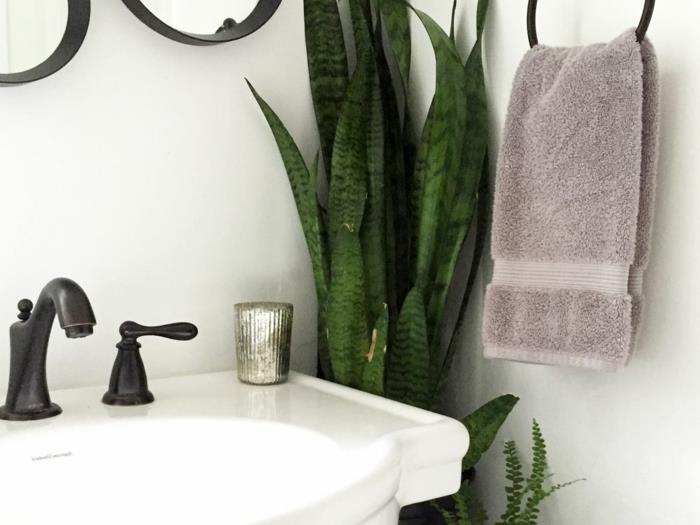banyo düzeninin detayları, banyo için bitkili köşe, siyah metal havlu askısı, taupe renginde havlu, vintage tarzda siyah lavabolu vintage beyaz lavabo