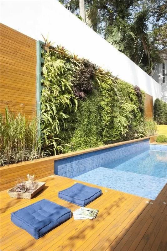 zunanji sistem zelenih sten, razporejen po celotnem bazenu v rastlinskem stilu ograje, ki ustvarja lep kontrast z leseno teraso in vodo