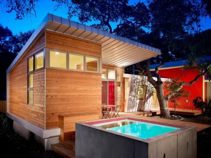 beton yükseltilmiş yüzme havuzu, ahşap ev, kırmızı duvar, ahşap bahçe masası