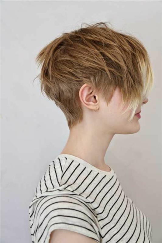 kratkodlaka blondinka, obrnjena na eno stran, razkuštrana in večplastna frizura, daljše šiške s svetlejšimi konicami