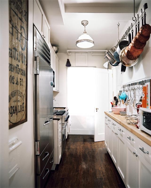 nasveti za shranjevanje v majhni kuhinji, razporejeni v dveh vrstah z belim pohištvom z delovno ploščo iz svetlega lesa