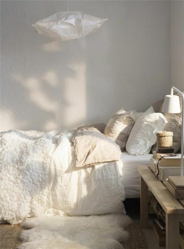 baltas kailis ant lovos, popierinė pakaba, baltos pagalvėlės, mažas austas krepšelis, balta stalinė lempa
