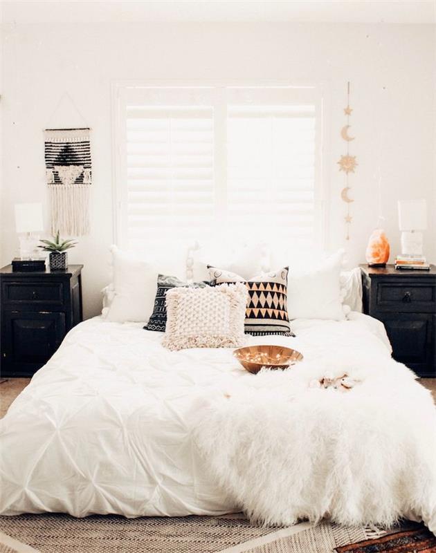 juodas naktinis stendas, spalvingos dekoratyvinės pagalvėlės, sieninė makrame, juodai baltas kilimas, prašmatnus retro skandinaviškas dekoras