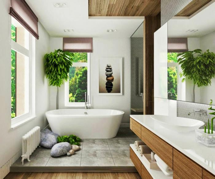 dviejų lygių vonios kambarys, pilkos plytelės ir sintetinis PVC parketas, ovali balta vonia, balta ovali kriauklė, medis kampe, kambariniai augalai