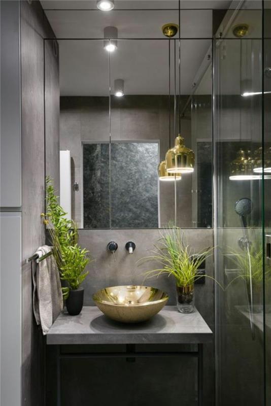 iç mekan bitkisi, banyo bitkisi, ışıksız banyo bitkisi, altın renginde küçük ve yuvarlak lavabonun her iki yanına yerleştirilmiş iki çeşit yeşil bitki, lüks atmosfer,