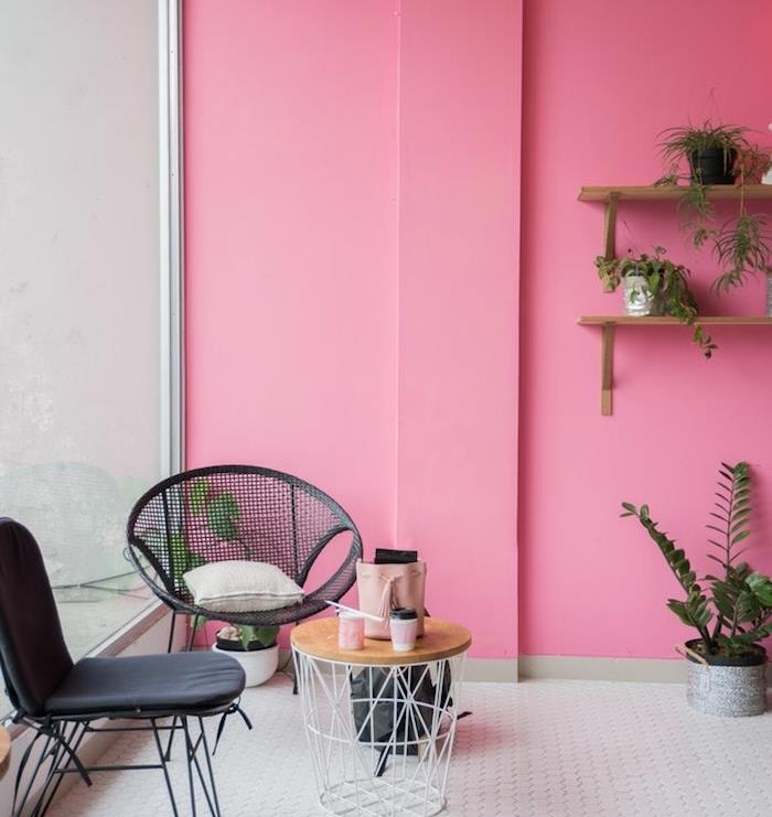 roza stene, tla iz belih ploščic, črni stoli in miza za smeti, lesene police, okrašene z rastlinami v majhnih zelenih lončkih