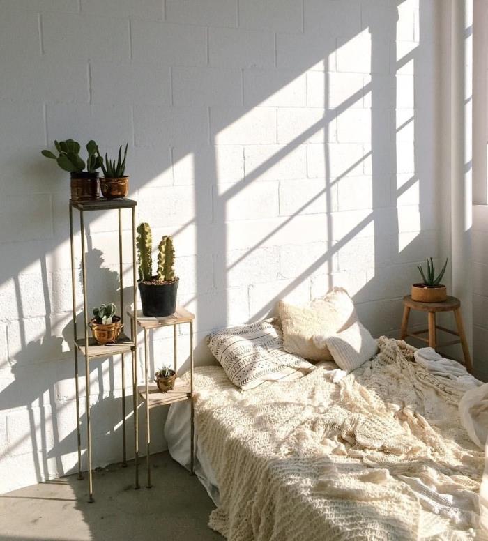 minimalistiniu ir bohemišku prašmatniu stiliumi apipavidalintas kambario modelis su lova ir nedideliu mediniu naktiniu stalu