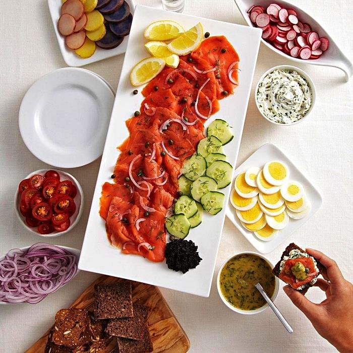 krožnik z rezinami dimljenega lososa, kumar, limone in zelenjave, da sestavite toast z aperitivom, zlomljene aperitivne sendviče