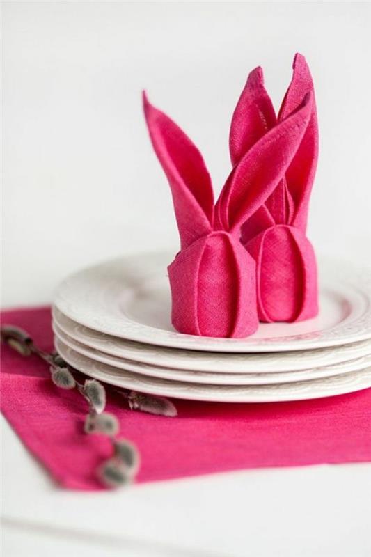 Bir tabağın ortasına yerleştirilmiş Paskalya peçetesi katlanır tavşan stili, DIY Paskalya dekorasyon fikri