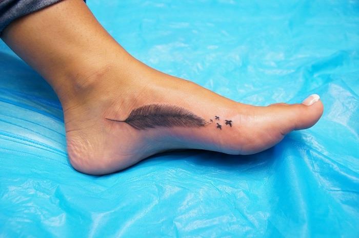 tatuiruotės idėjos moteris, piešianti ant odos paukščiais ir plunksnų raštu, tatuiruotė ant pėdos