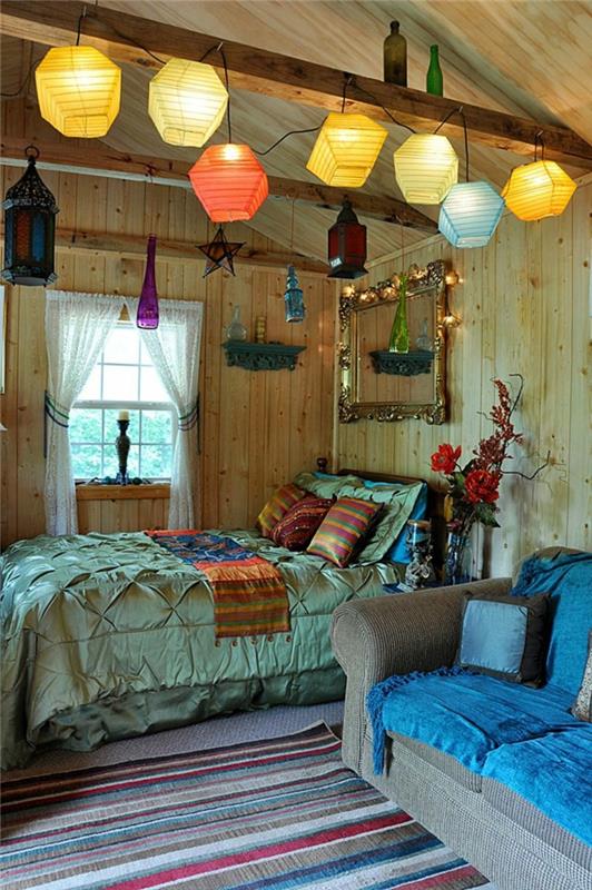 bohem dekor, büyük mavi kanepe, asılı lambalar, ahşap tavan ve duvarlar, çizgili halı ile çingene odası