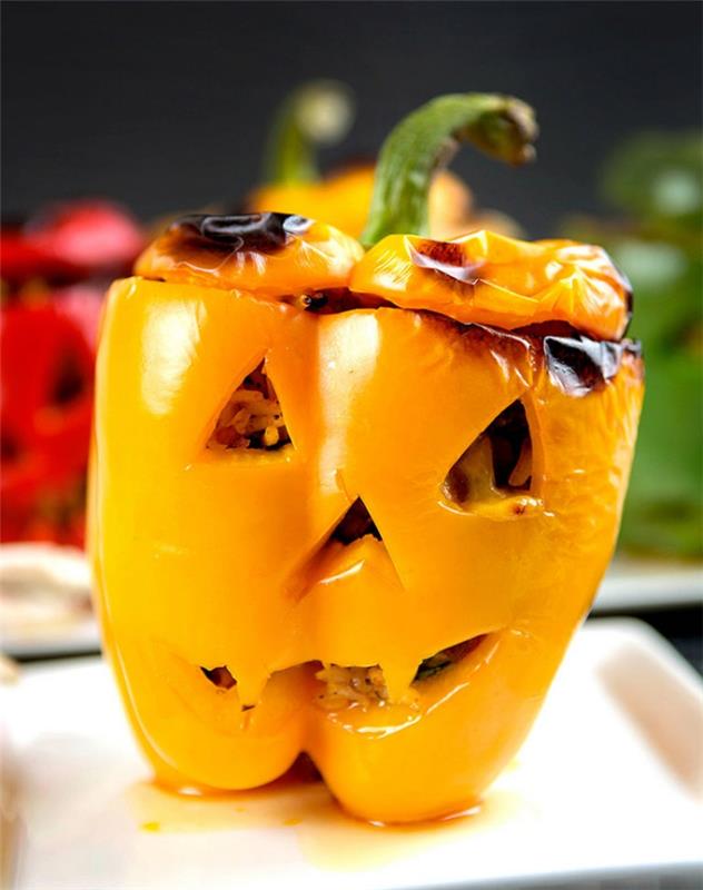halloween polnjene paprike narezane kot sablasne buče halloween lučke, ki služijo kot glavna jed