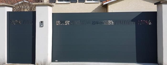 črna aluminijasta vrata z umetniškimi izrezi, povezana z belo ograjo