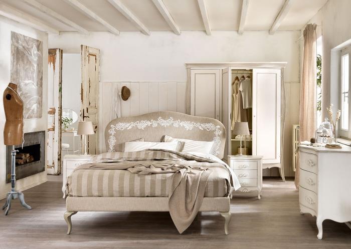 yeniden boyanmış eski püskü şık mobilya ve beton şömine ile beyaz duvarlı yetişkin yatak odası
