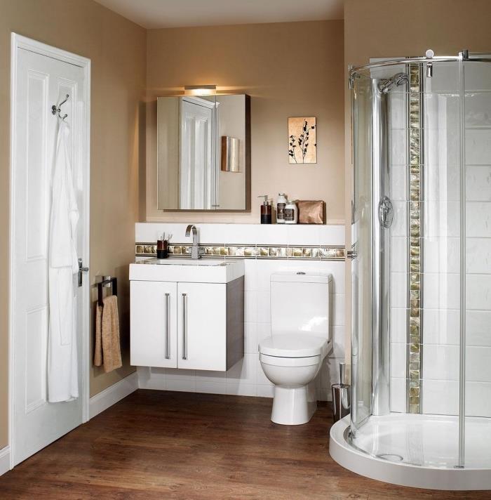 postavitev majhne kopalnice z bež stenami z rjavim podom in belimi umivalniki ter tuš kabinami