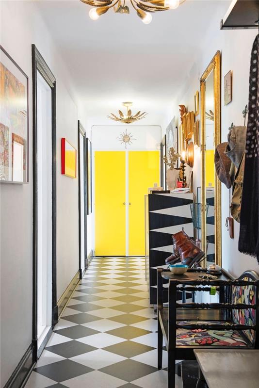 fluorescentno rumena barva notranjih vrat, ki ustvarja občutek globine v tem grafičnem hodniku s črnimi in zlatimi poudarki