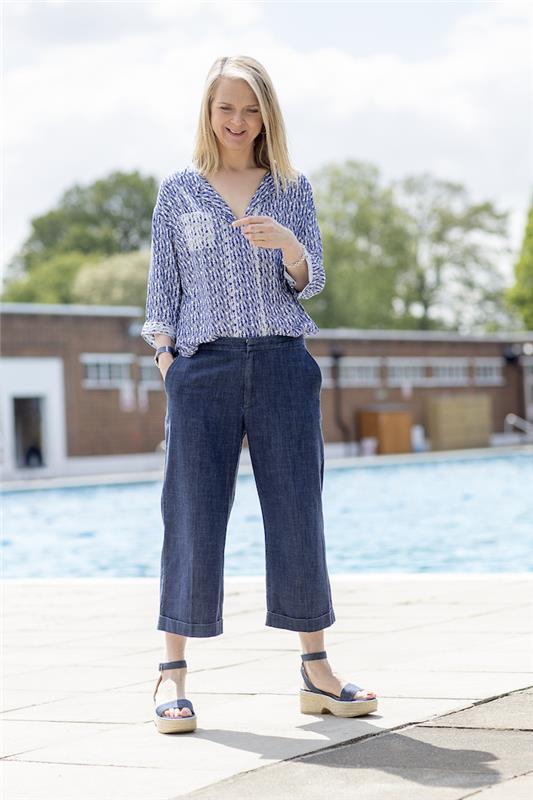 dėvi džinsus 60 vasaros moterų aprangos idėja su džinsinėmis kelnėmis ir šviesiais margintais marškiniais su sandalais 60 metų moters išvaizda