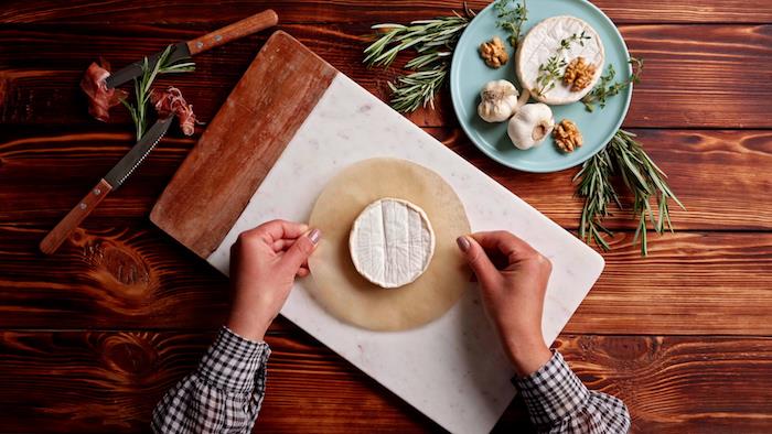 položite brie na kos papirja za peko, da naredite izviren in prefinjen francoski aperitiv iz tapasa z briejpg