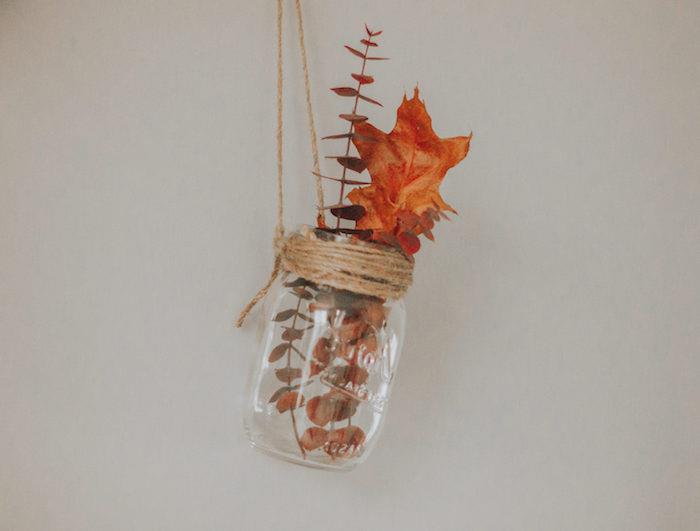 jesensko dekoracijo naredite sami z recikliranim steklenim kozarcem, ki visi na vrvici z drevesnimi listi in posušeno drevesno vejo
