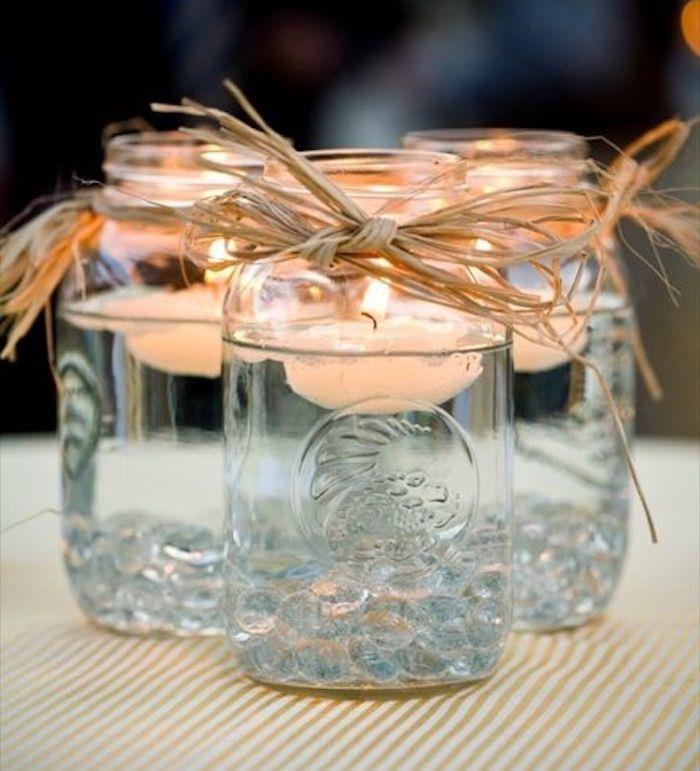 preprost kmečki eleganten poročni dekor, stekleni kozarec, preoblikovan v svečnik z oljem in plavajočimi svečami