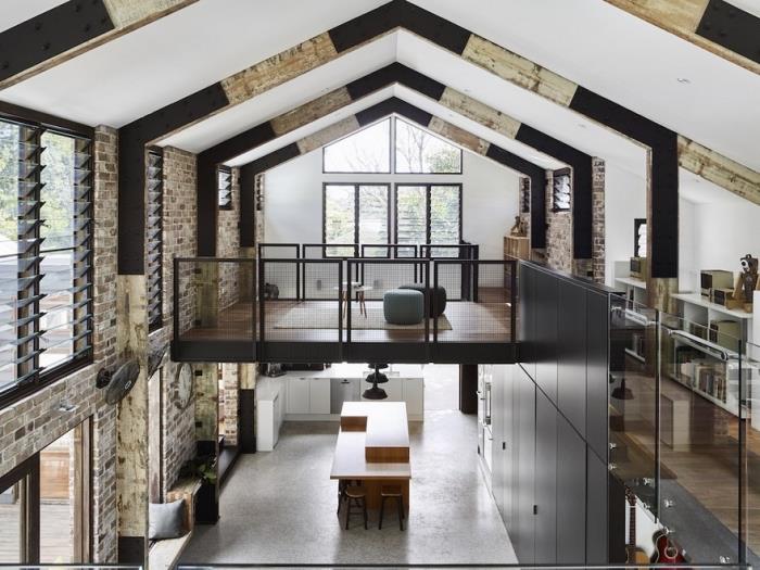 Bir ahırın bir eve nasıl dönüştürüleceğine dair örnek, çimento zeminli ve mat siyah desenli endüstriyel çatı katı tarzında iç tasarım