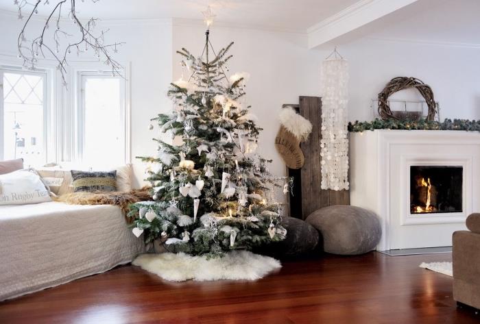 kahverengi ve gri mobilyalı koyu parke zeminli beyaz bir oturma odasında koza tarzı iç tasarım, beyaz ve gri Noel ağacı dekorasyonu