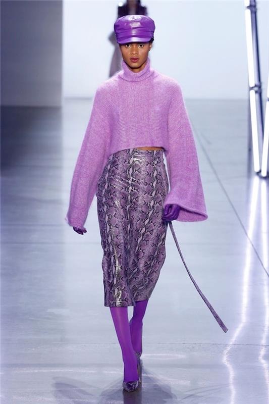 ženska, oblečena v vse vijolične, oblačilne trende 2019, usnjeni klobuk in rokavice, usnjeno krilo in pulover z vijolično kačjo kožo