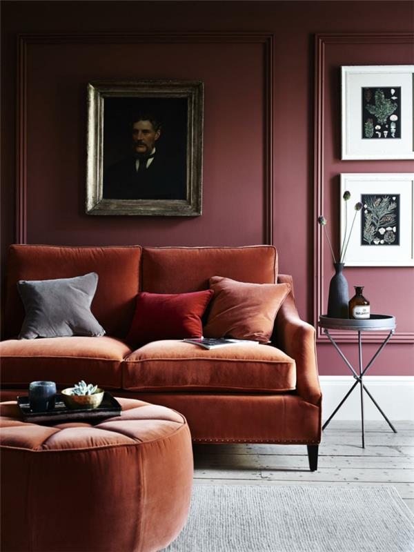vijolična postavitev dnevne sobe z oranžnim kavčem, za barvo terakota, črna nočna omarica, okvirji za slike