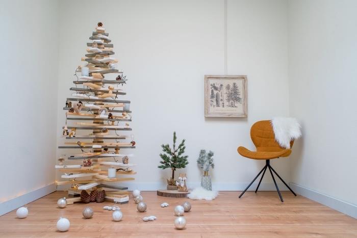 doğal ve minimalist bir dekor için ahşap kilitlerle yapılmış ahşap bir Noel ağacı, Noel süsleri ile süslenmiş Noel ağacı rafı