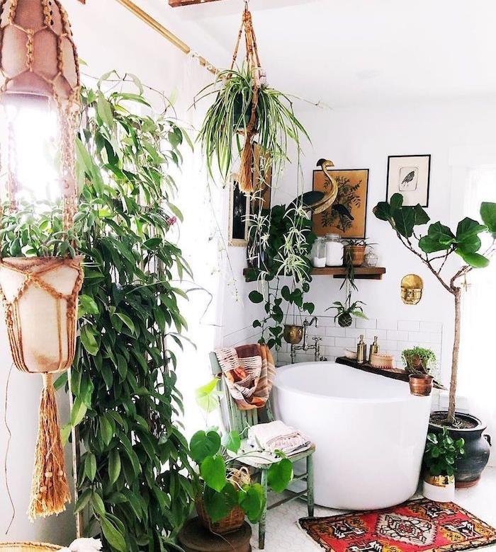 kopalnica v džungli z majhno kotno kadjo, lesena vogalna polica, majhen orientalski apis, ploščice in bela barva, vzorec džungle skozi rastline