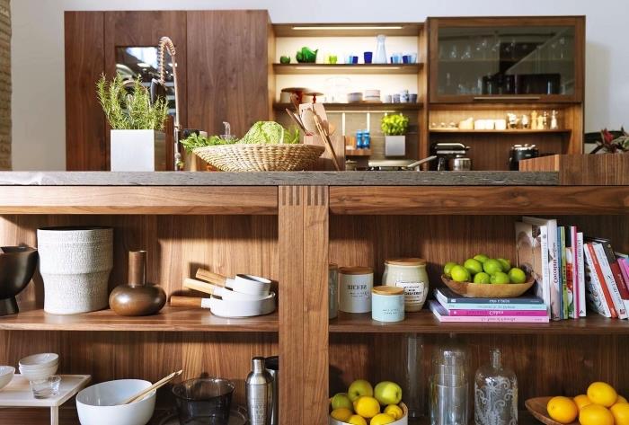 lesena kuhinjska omara z belimi stenami s policami in omarami iz temnega lesa ter zasteklitvijo, kuhinjsko shrambo za sestavine in predmete