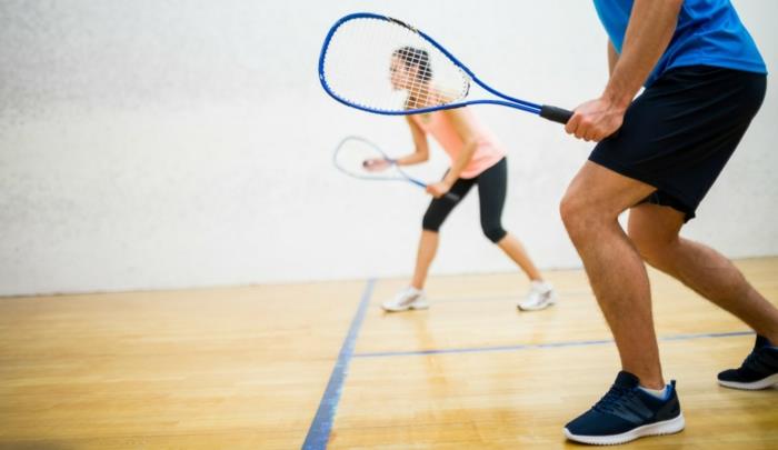 športni trening, squash dvorana, modri loparji za squash, moške kratke hlače, ženske ženske superge