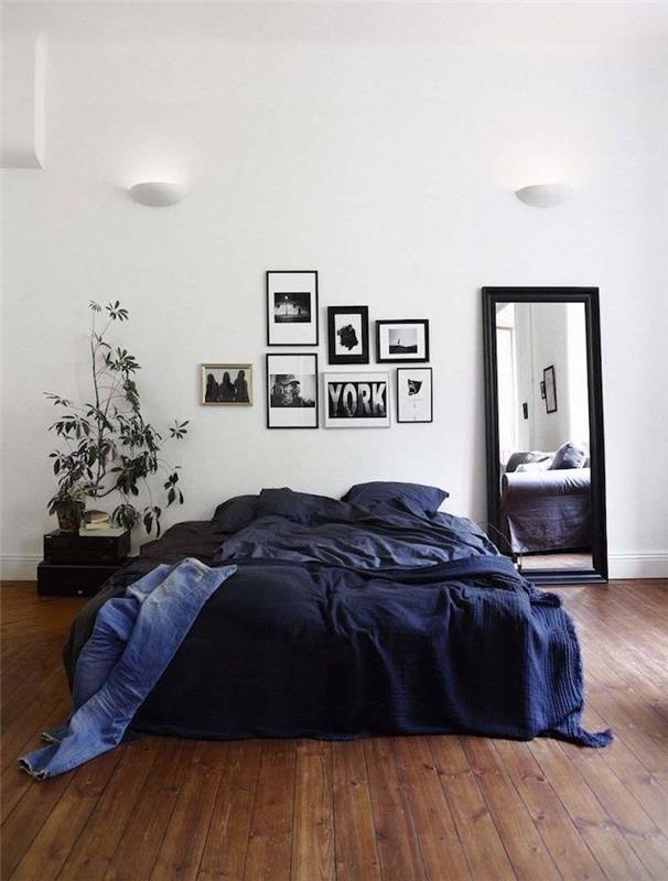 Skandinavski model vzglavja v okvirjih za fotografije in črno -beli risbi, modro posteljnino, rjav parket