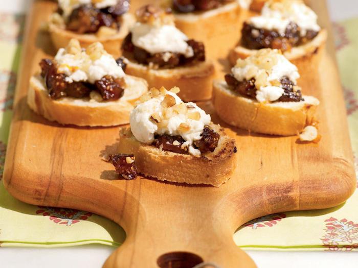 bruschetta receptas skrudinta duona su figomis ir rikota su riešutais ant pjaustymo lentos, šalto tapas recepto aperityvas