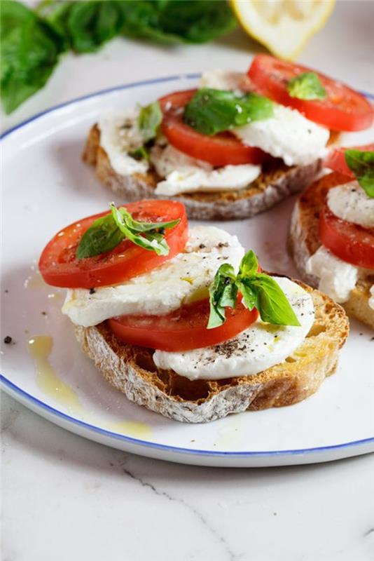 kızarmış köy ekmeği bruschetta'da servis edilen caprese salatası, mozzarellalı klasik İtalyan tostu, domates ve fesleğen