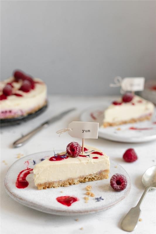 torta z mascarponejem brez pečice, malinovim in belim čokoladnim cheesecakeom na ozadju zdrobljenih piškotov in masla, okrašena z malinovim coulisom