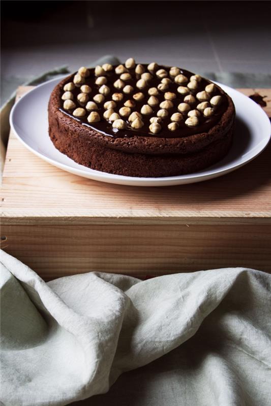 ideja za okusno in zelo enostavno narediti torto iz nutelle, okrašeno s celimi lešniki
