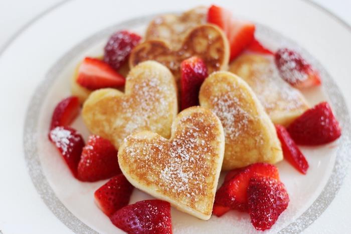 Sevgililer Günü kahvaltı yemeği fikri, üzerine pudra şekeri ve çilek ile doldurulmuş orijinal kalp şeklinde krepler