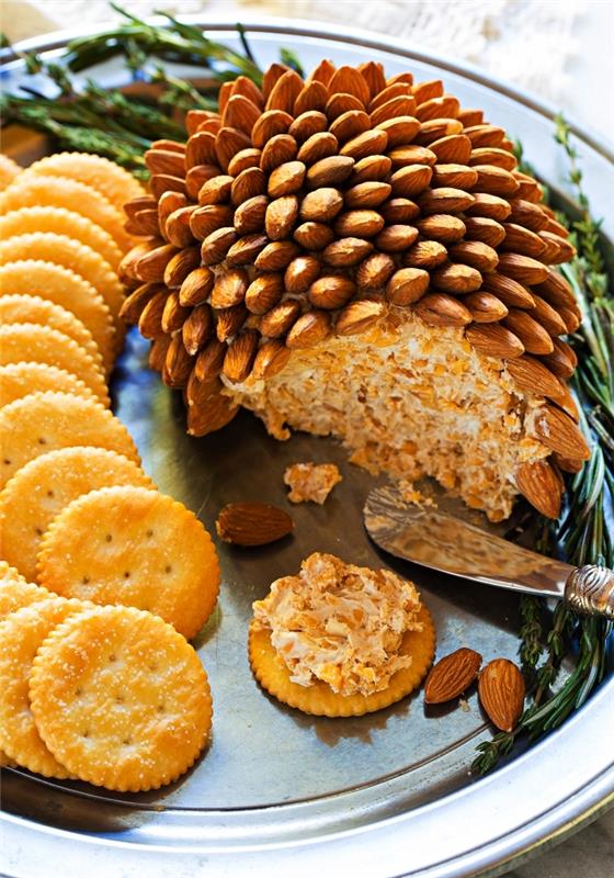 recept s sirovo kroglico in mandlji za enostaven in hiter božični aperitiv, krožnik z ocvirki in sirova kroglica v obliki borovega storža