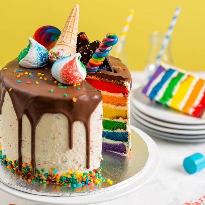 Üzerinde çok renkli bezeler ve dondurma külahları bulunan, akıcı çikolatalı krema ile gökkuşağı pastası dekorasyonunun orijinal fikri