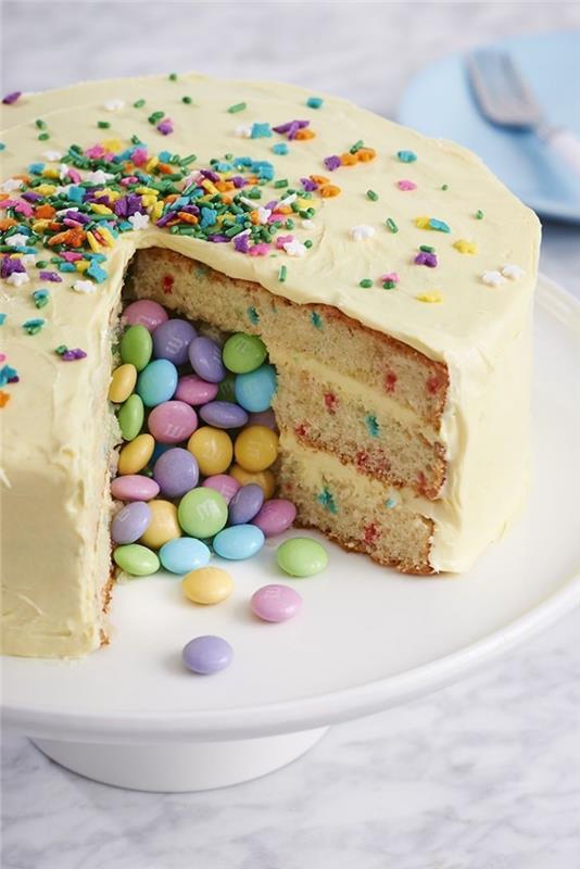 smarties torta v pastelnih barvah z več plastmi mehkega biskvita, premazanega s pecivo