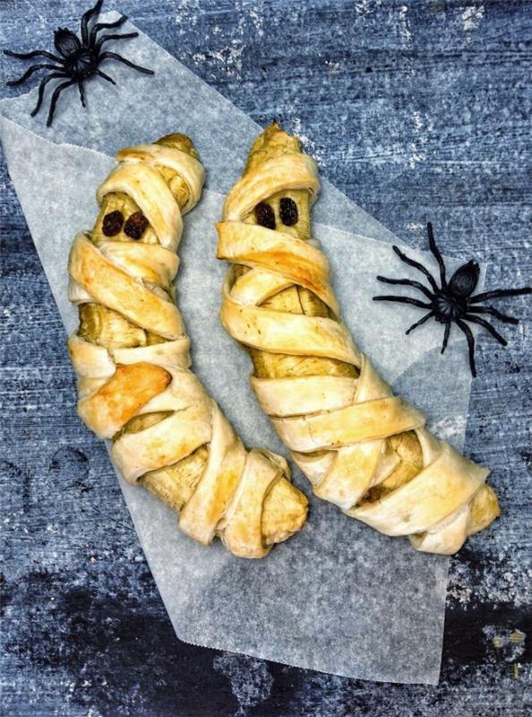 pečene banane v slogu mumije v slogu halloween, zavite v listnato testo z rozinami kot očmi