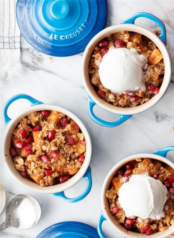 naminis obuolių trupinys su granola ir granatu, patiekiamas su kaušeliu vanilinių ledų